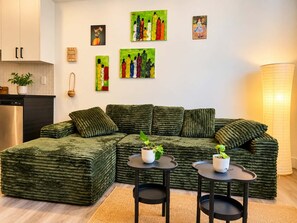 A modern living room with a sectional sofa, two side tables, and artwork on the walls. - Big 2 rooms appartement 5mn from metro cote ste catherine / pet friendly (Montréal)