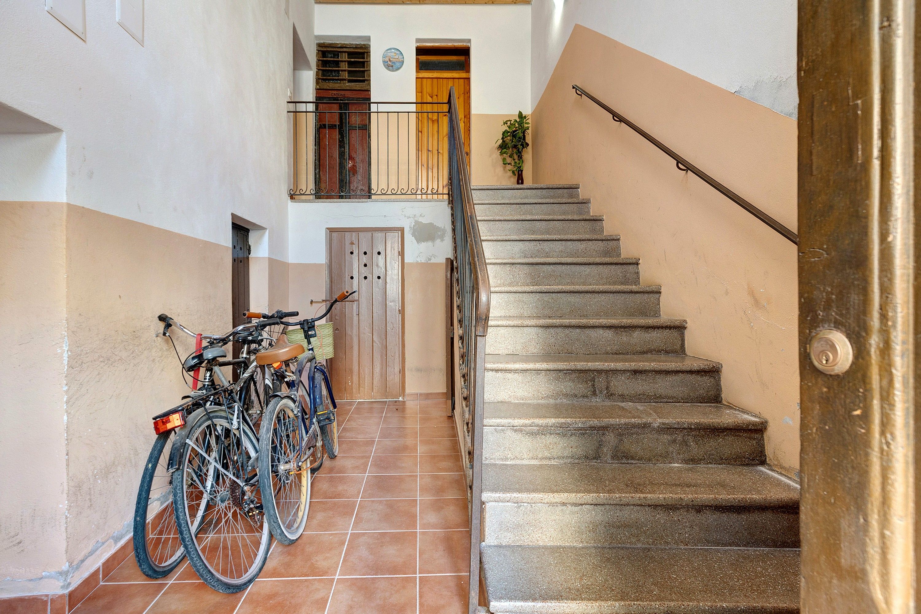 A staircase with a metal handrail leading to a wooden door at the top.