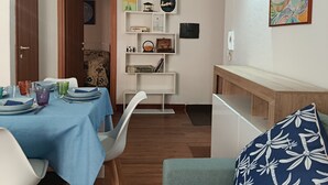 En matplats med ett blått bordsduksklätt bord, vita stolar och ett träpanelat tak.