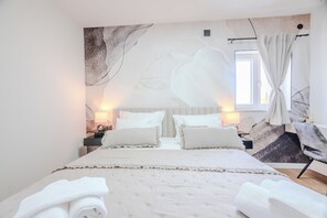 A bedroom with a large bed, two bedside tables, a window with curtains, and a wall mural. - A1 - luxury apartment near beach with big terrace and the sea view (Kaštel Gomilica)