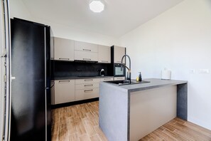 A modern kitchen with a built-in refrigerator, a microwave, and a sink. - A1 - luxury apartment near beach with big terrace and the sea view (Kaštel Gomilica)