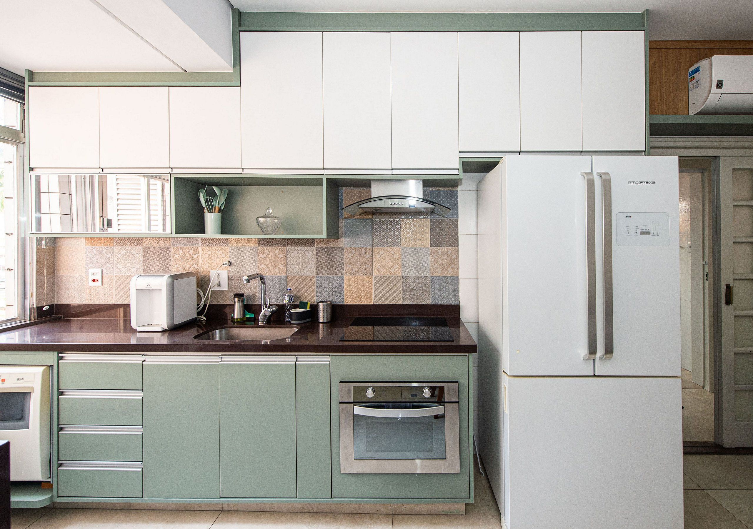 Una cocina equipada con horno empotrado, refrigerador y microondas.
