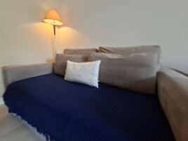 A bedroom with a bed, a nightstand, a lamp, and a window.
