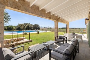 Eine Außenpatio mit Pool, Sitzgelegenheit und Blick auf die Landschaft.
