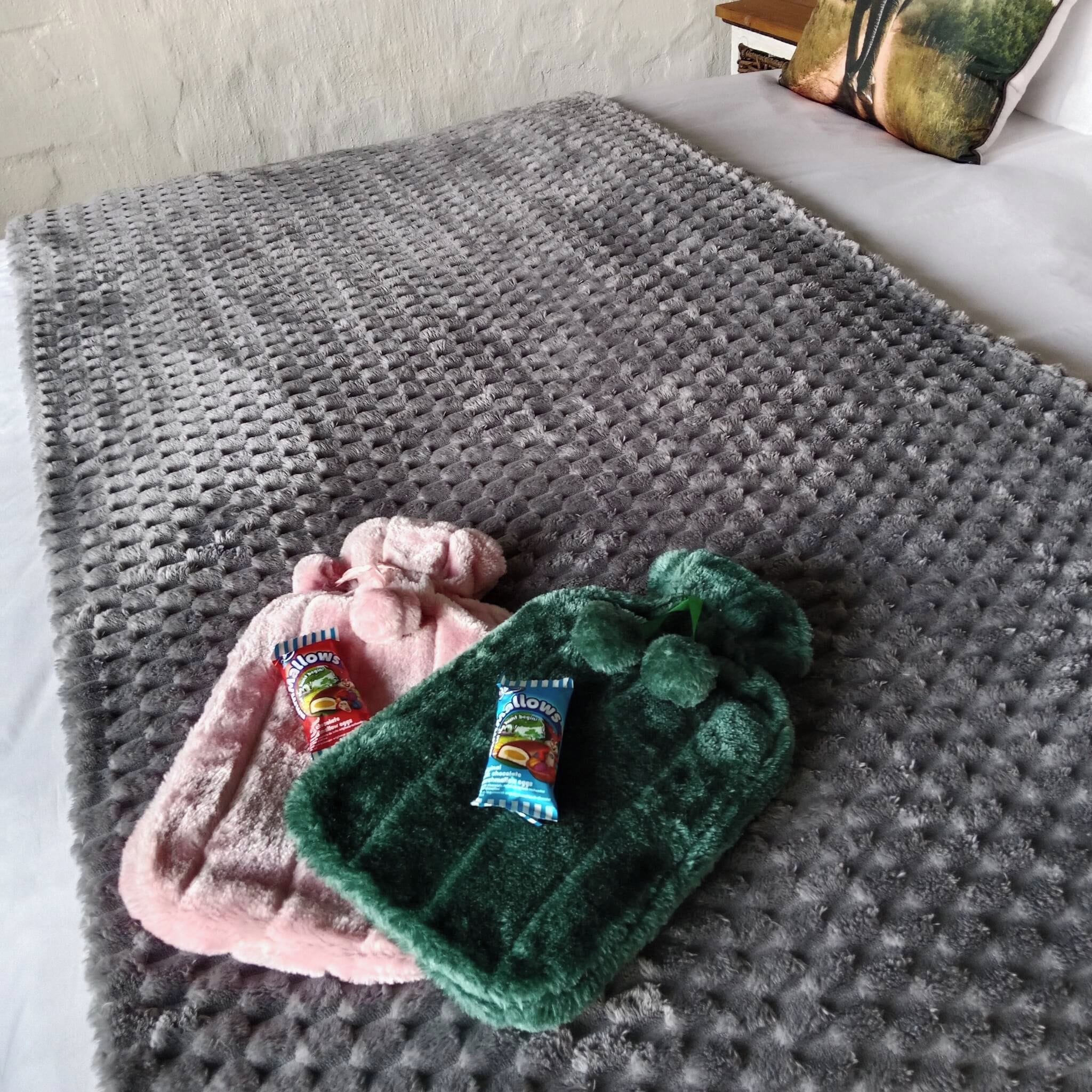 A textured grey rug with two plush toys on it.