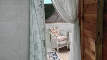 A room with a bed, a chair, and a patterned rug.