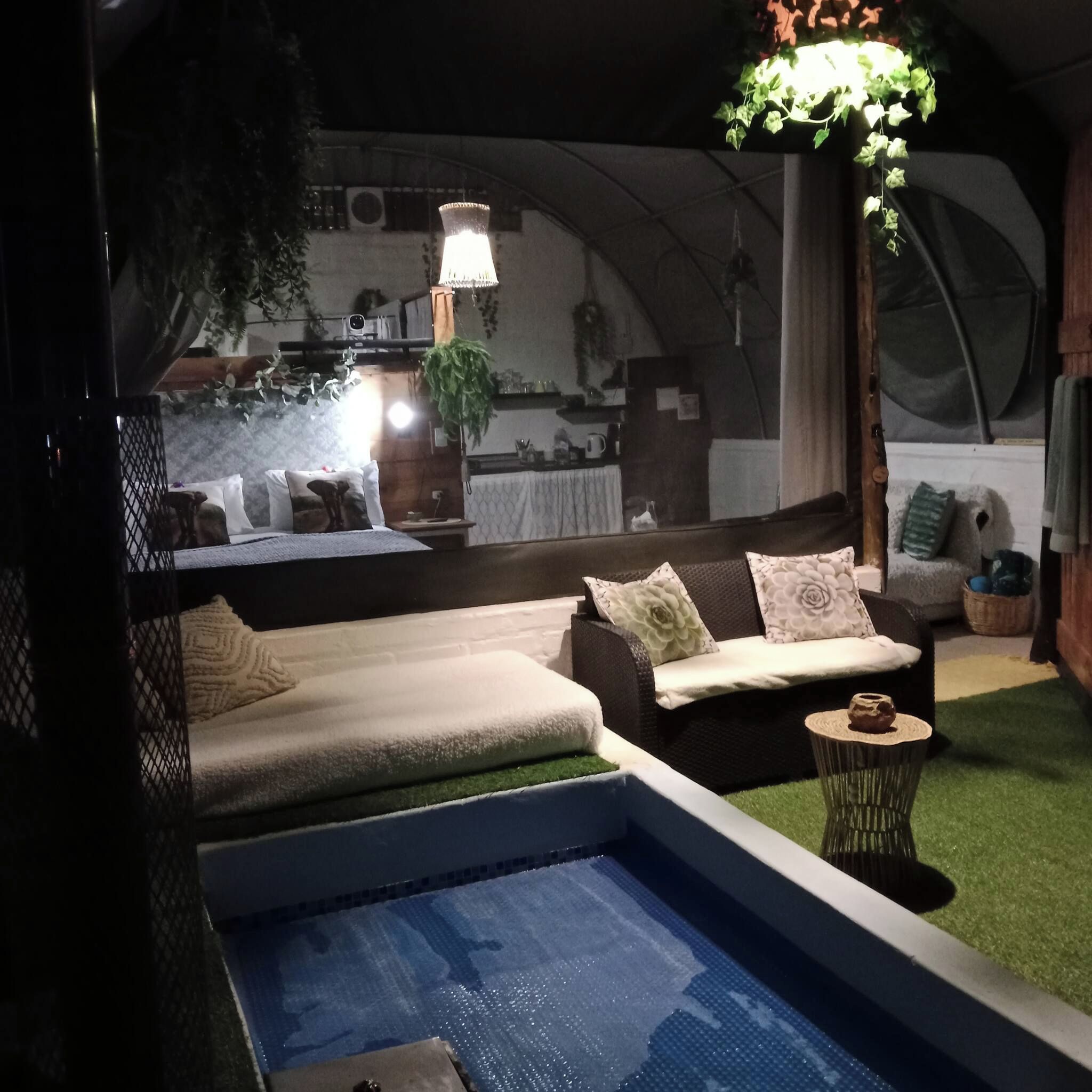 A cozy indoor setting with a pool, seating area, and a kitchen in the background.