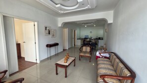 A spacious living area with a sofa, a coffee table, and a dining table set for two.