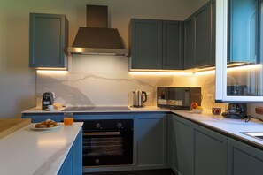 A modern kitchen with a built-in oven, a coffee maker, and a microwave. - Villa Cammà with private pool (Mirto)