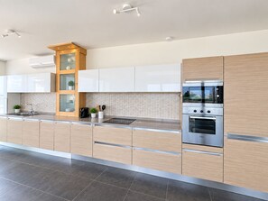 A modern kitchen with a built-in oven, a coffee maker, and a plant on the counter. - Rokna corner penthouse - 240sqm with sea view in Xaghra Gozo (Ix-Xagħra)