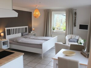 Ein modernes Schlafzimmer mit Bett, Nachttischen, Schreibtisch und Stuhl.