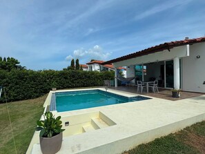 A swimming pool with a patio area, a hammock, and a view of neighboring houses. - Very spacious house near the beaches in Nueva Gorgona, Malibu Beach, and Casa Kai (Nueva Gorgona,residencial malibu)