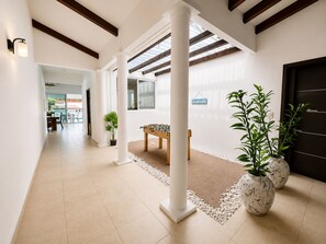 A spacious corridor with a foosball table, potted plants, and a clear view to the outside. - Very spacious house near the beaches in Nueva Gorgona, Malibu Beach, and Casa Kai (Nueva Gorgona,residencial malibu)