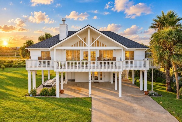 A two-story house with a balcony, a chimney, and a well-maintained lawn.