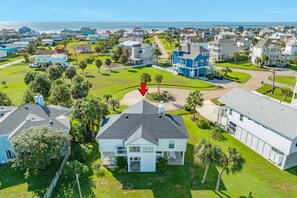 A residential area with houses, a clear sky, and a view of the ocean.