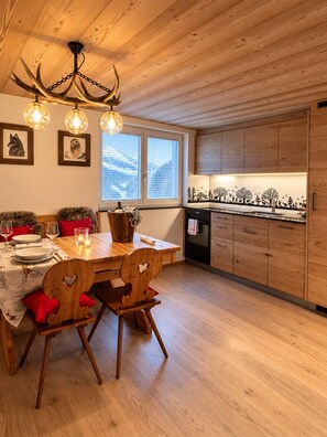 Ein Essbereich mit einem Holztisch, Stühlen und einer Kronleuchter.