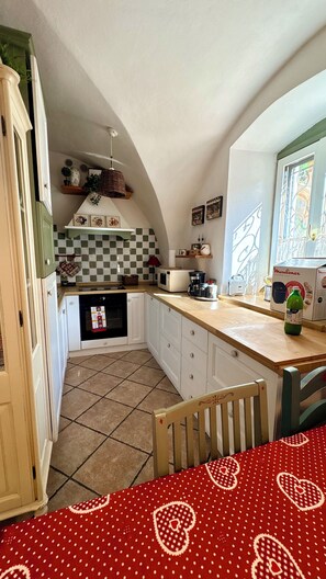 A compact kitchen with a microwave, coffee maker, and a bottle of drink on the counter. - Sopramonte Apartment and Annex (Sopramonte)