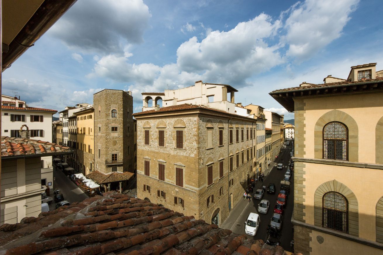 A street view with historic buildings, a cobblestone street, and a clear sky.