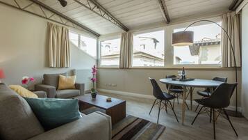 Uma sala de estar moderna com sofá, mesa de centro e área de jantar.