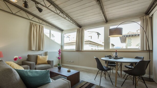 Ein modernes Wohnzimmer mit Sofa, Couchtisch und Essbereich.