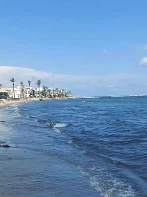 Vista costera con playa, océano y edificios.