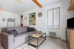 A living room with a sofa, coffee table, and a TV on a wooden stand.