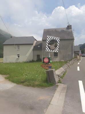 Ein Verkehrsschild mit reflektierender Oberfläche, einem Richtungspfeil und einem kleinen Schild mit Text.