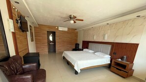 A bedroom with a bed, a chair, a TV, and a ceiling fan. - MARIA BONITA BY CHAVIRA NUEVO LAREDO (Nuevo Laredo)