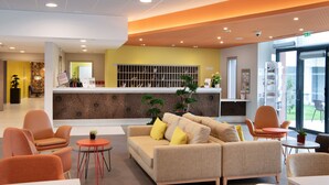 A modern lobby with a reception desk, seating area, and a large window. - DOMITYS - Les Passementiers (Villars)