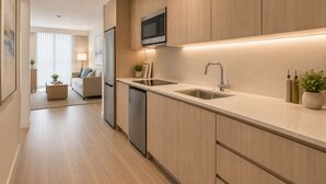 A modern kitchen with wooden cabinets, stainless steel appliances, and a built-in microwave. - Downtown Top Suites - S Avenue  (Toronto)