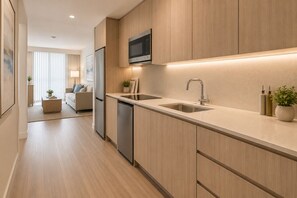 Una cocina moderna con armarios de madera, electrodomésticos de acero inoxidable y un microondas integrado.