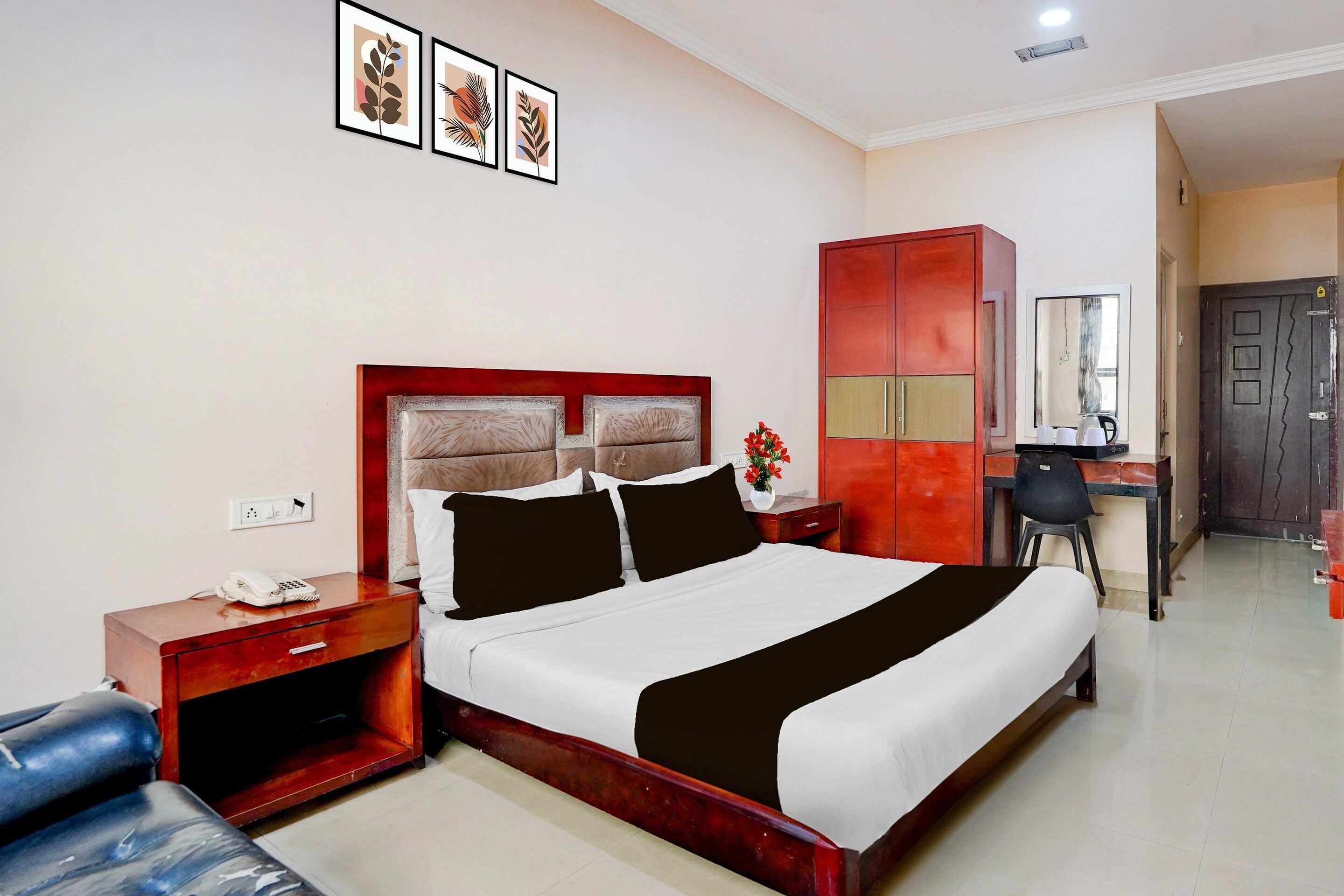 A hotel room with a bed, a desk, a wardrobe, and a chair.