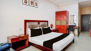 A hotel room with a bed, a desk, a wardrobe, and a chair.