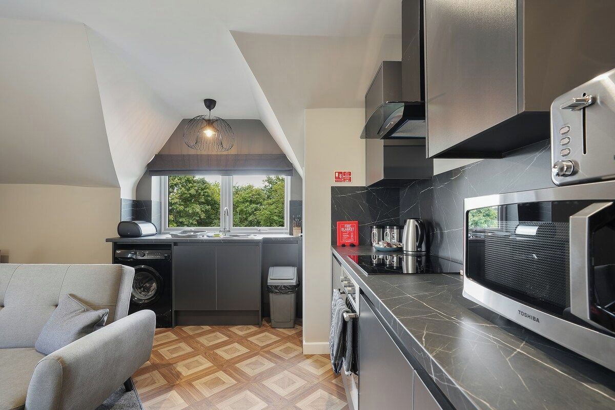 A compact kitchen with a built-in washer, a microwave, and a toaster.