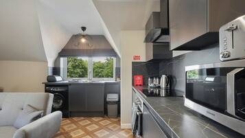 A compact kitchen with a built-in washer, a microwave, and a toaster.
