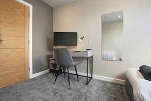 A room with a desk, chair, and a bed. - The Olive Tree | Stylish 2-Bed Loft (Kingston upon Hull)