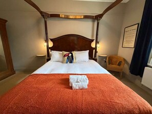 A hotel room with a four-poster bed, a red blanket, white pillows, and a folded towel on the bed. - El Toro · Boutique King Room in Cardiff Bay - 1 (Cardiff)