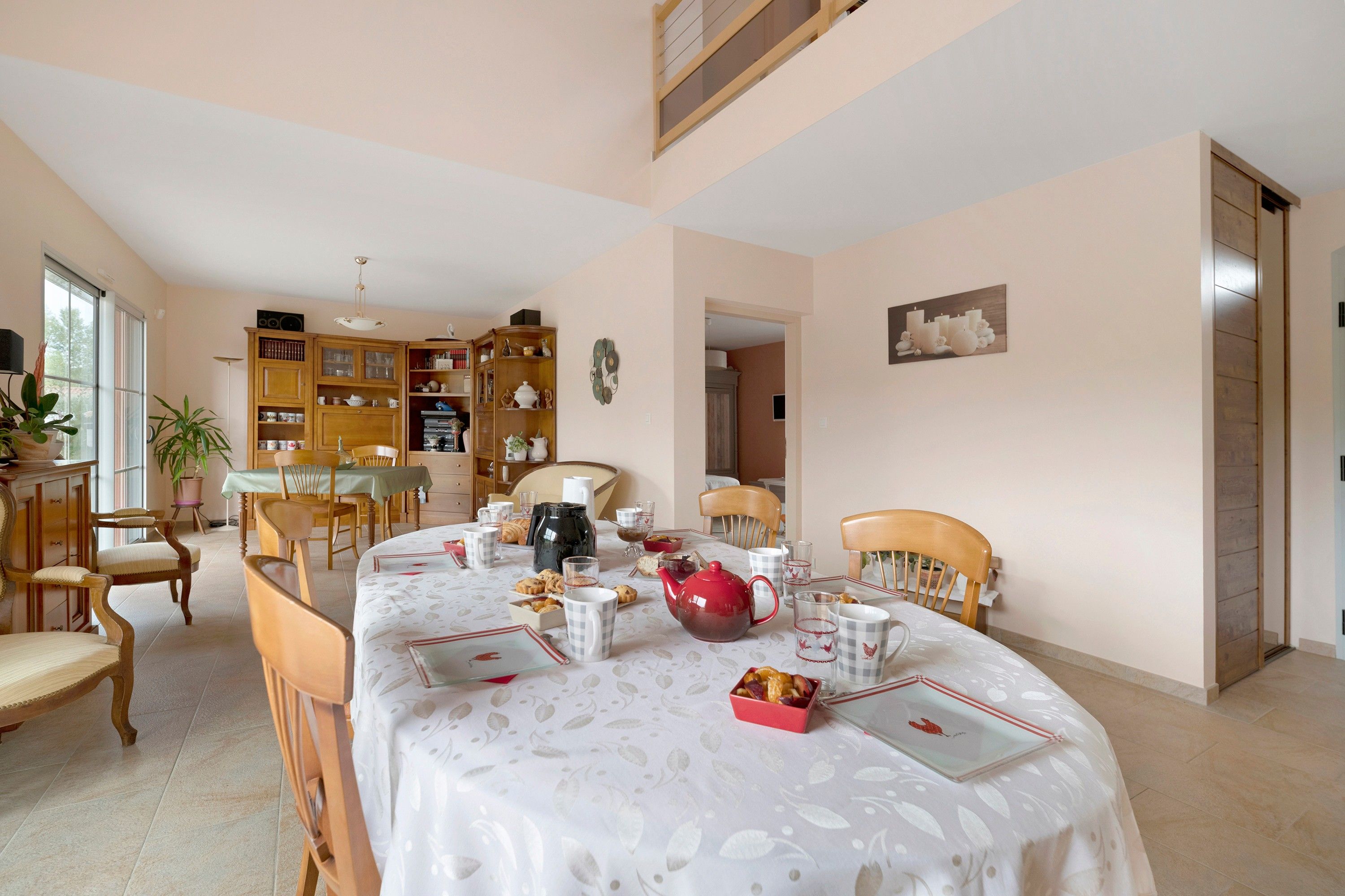 Un comedor con una mesa dispuesta para cuatro personas, rodeada de sillas de madera.