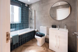 Une salle de bain moderne équipée d’une douche, de toilettes, d’un lavabo et d’un miroir.