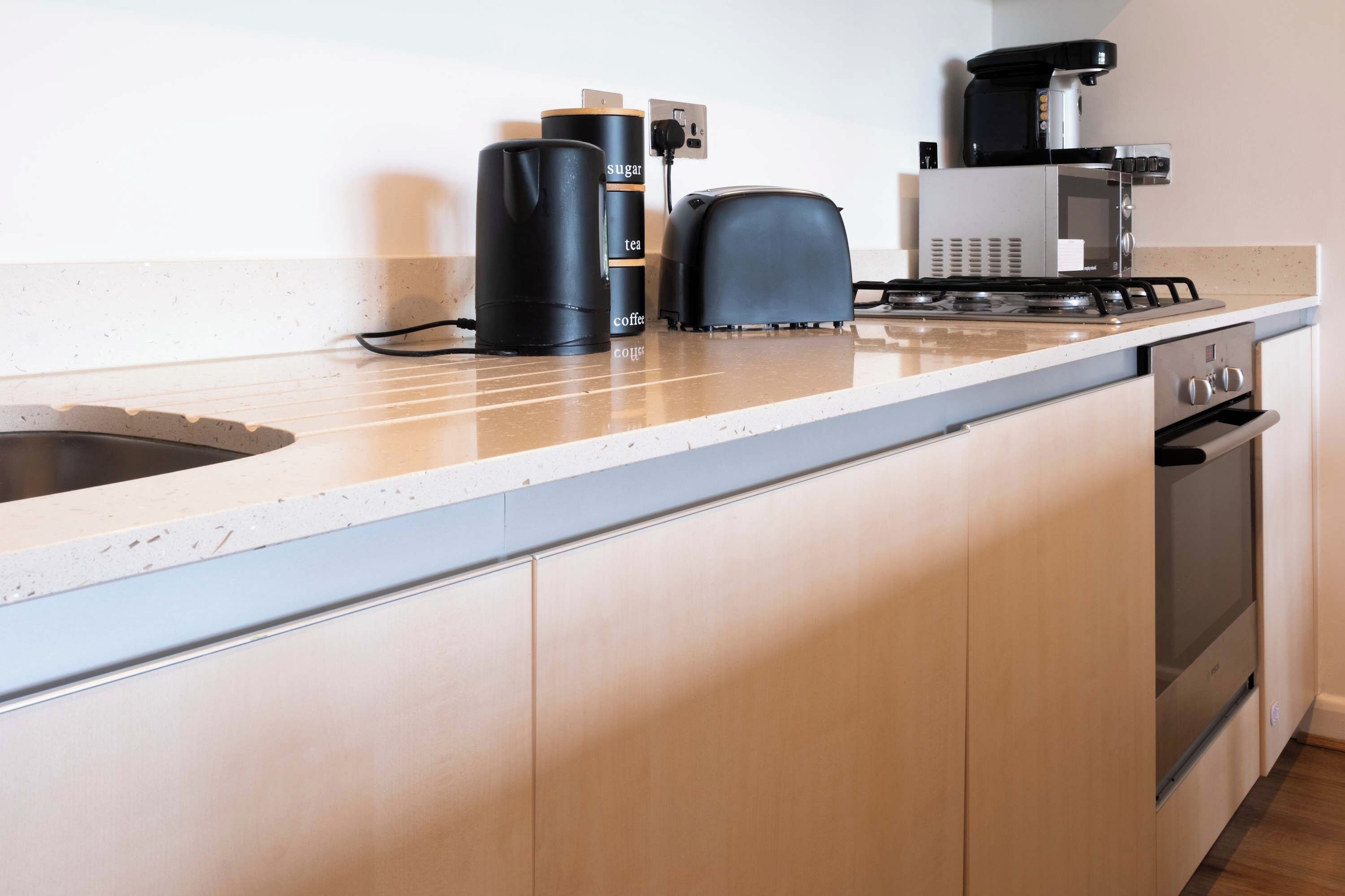 A kitchen with a countertop, a coffee maker, a toaster, and a stove.
