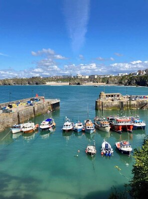 A harbor with boats docked, a pier, and a stone building in the background. - Luxury Fistral Beach Apartment Newquay, Cornwall Parking (Cornwall)
