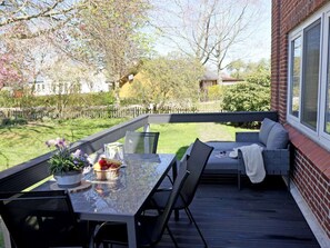 An outdoor deck with a table, chairs, and a cushioned seating area. - Holiday Apartment With 1 Bedroom (Dollerup)