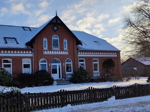 A two-story brick house with a symmetrical facade, a central entrance, and a snow-covered yard. - Holiday Apartment With 1 Bedroom (Dollerup)