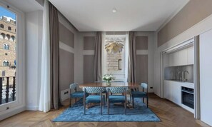 A dining area with a table, chairs, and a view of a building through a window. - STUNNING 5-BEDROOM HOME WITH PRIVATE TERRACE & PIAZZA VIEWS (Firenze)