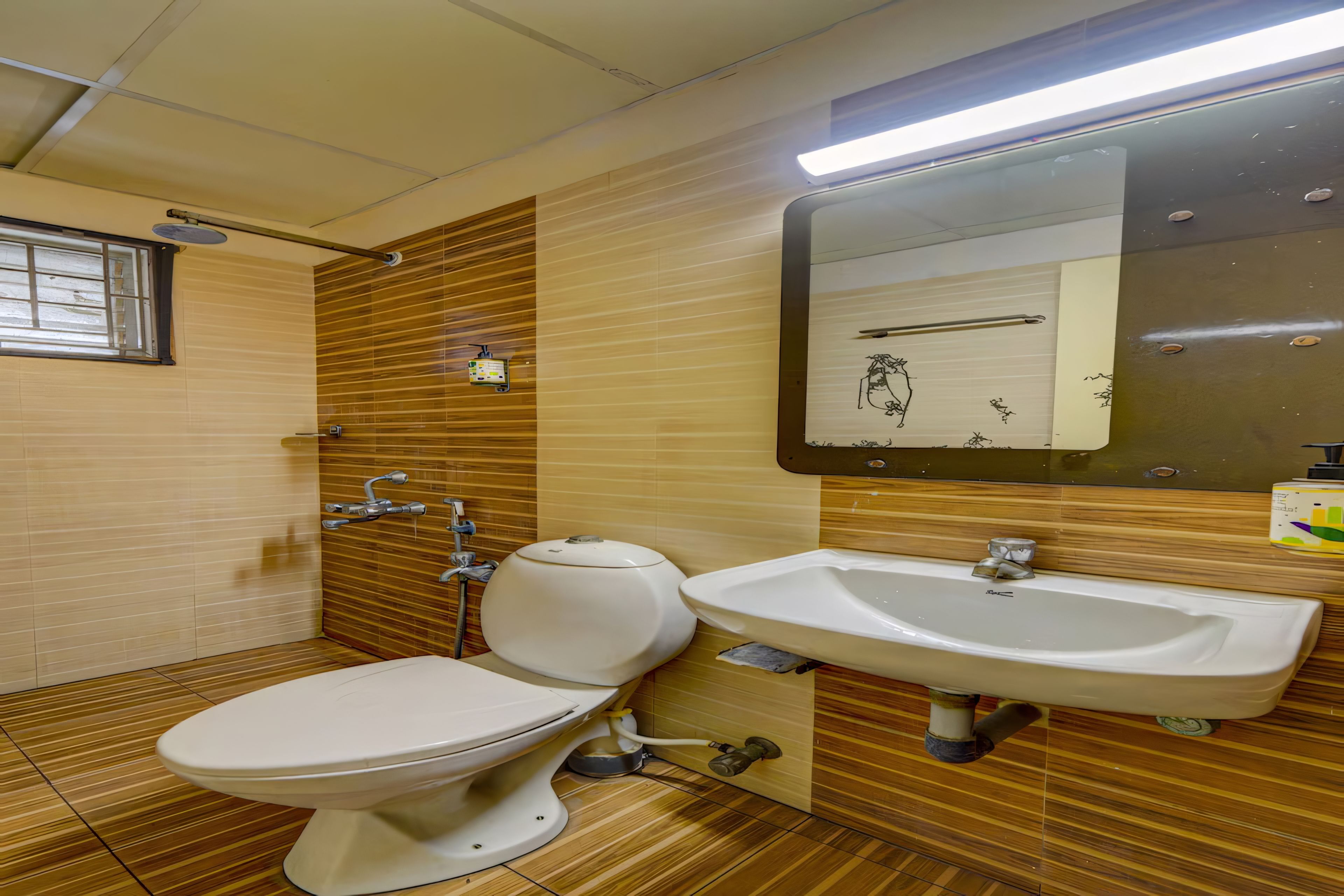Un bagno con il water, un lavandino e uno specchio.