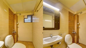 Un baño con dos inodoros, un lavamanos y un espejo.