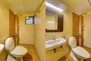 A bathroom with two toilets, a sink, and a mirror. - XOTEL ASHOKNAGAR (Chennai)