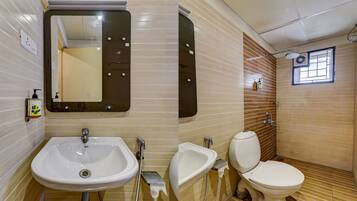Un baño con lavamanos, bidé, inodoro y espejo.