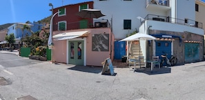 A street view with a small kiosk, a bicycle, and a building with a balcony.