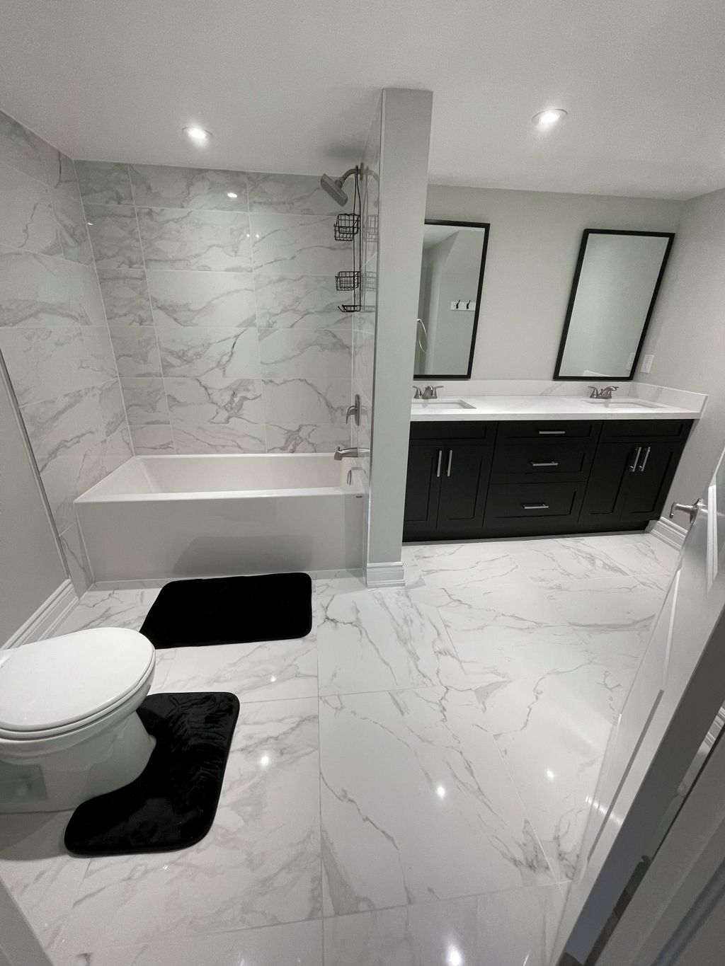 Ein modernes Badezimmer mit Badewanne, Toilette und Waschtisch.
